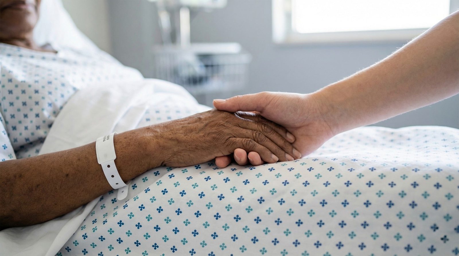 Una mano anziana stretta da quella di un familiare